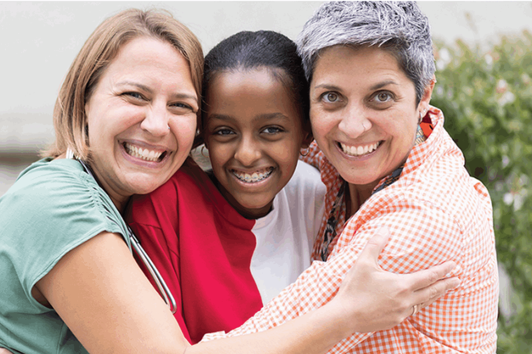 Image of two white women hugging a teenager