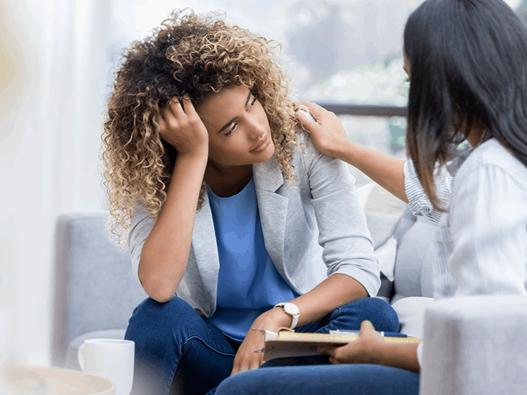 Young woman in distress sitting talking to a doctor