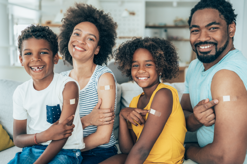 Image of a family with bandaids on their arms after getting vaccinated.