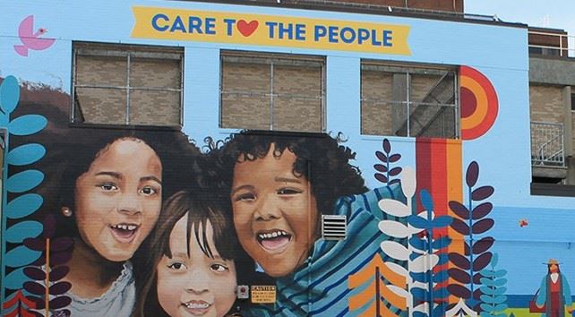 Mural of young children on the side of a building