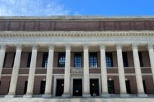 Photo of the outside of a Harvard Library, with bricks steps and vertical columns