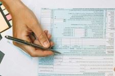 Image of a woman writing down information on a form