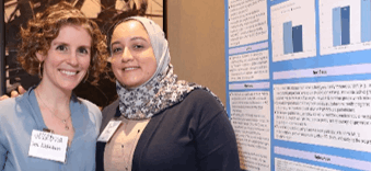 Photo of two female researchers in front of a research poster