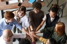 Young researchers in a circle with their hands in the center